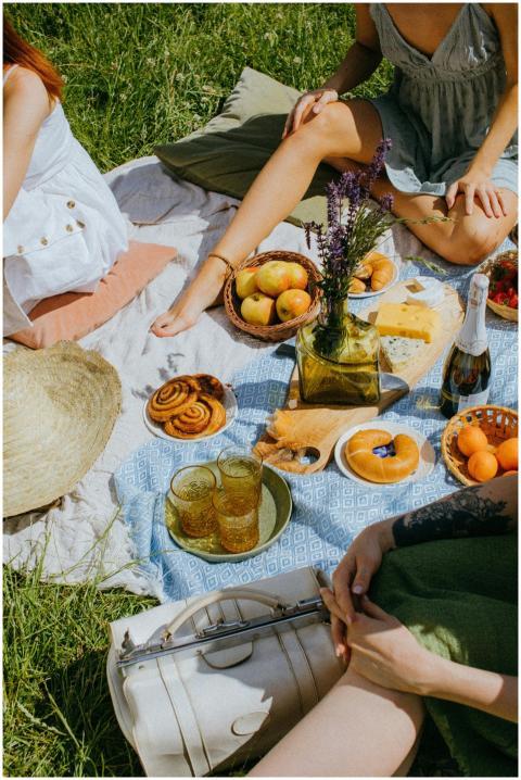 Enjoying a sunny picnic with fruits, pastries, and