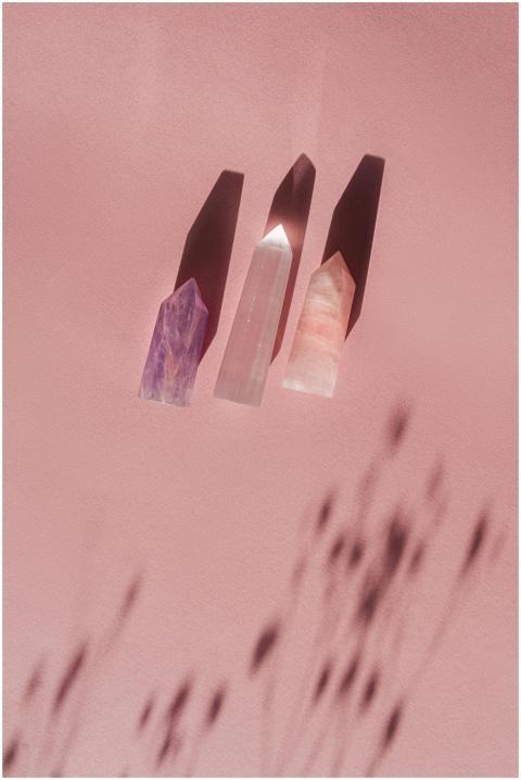 Three polished crystals casting shadows on a soft