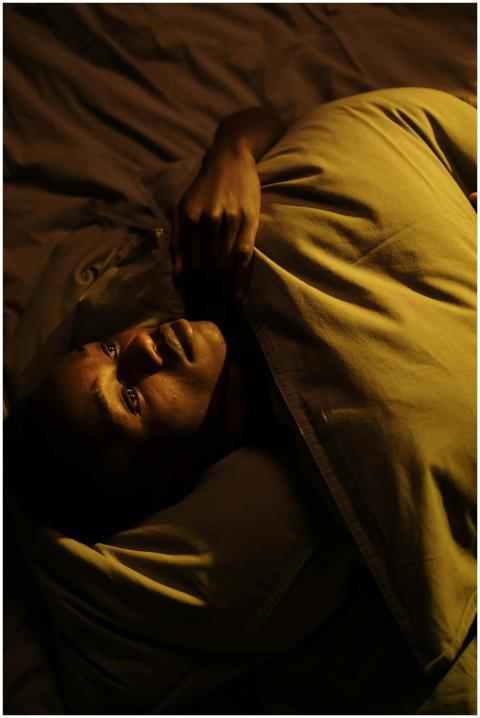 Serene scene of a man lying in bed at night, captu