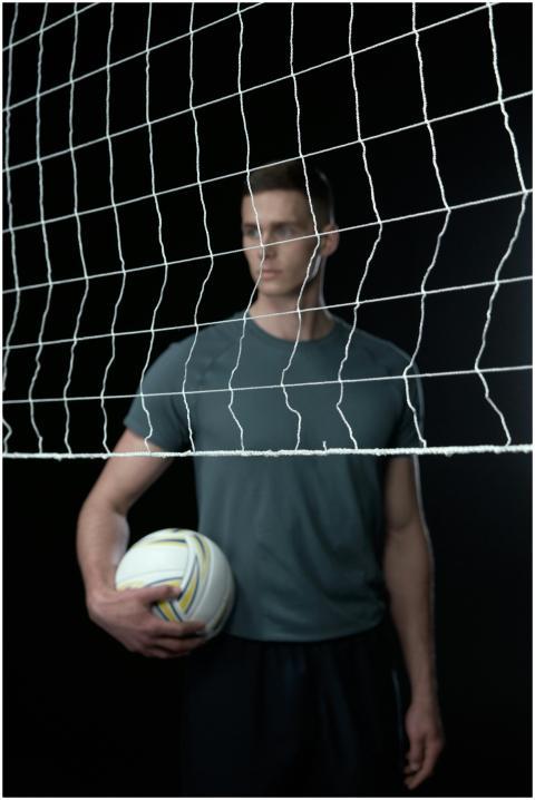 Focus on a male volleyball player standing behind
