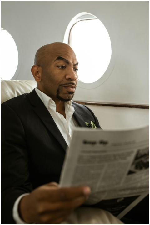African American man in suit reading newspaper in