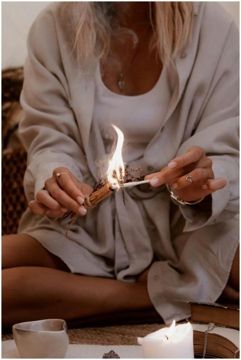 A woman performing a candle ritual indoors, creati