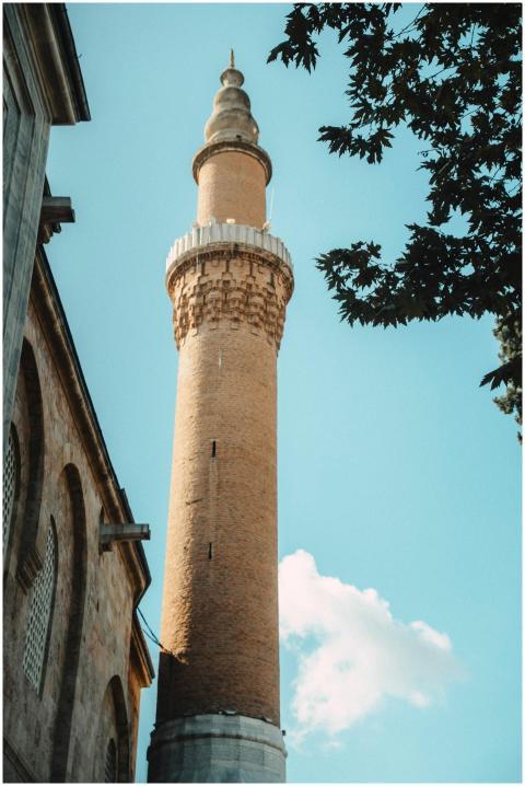 A towering historic minaret reaches up into the cl