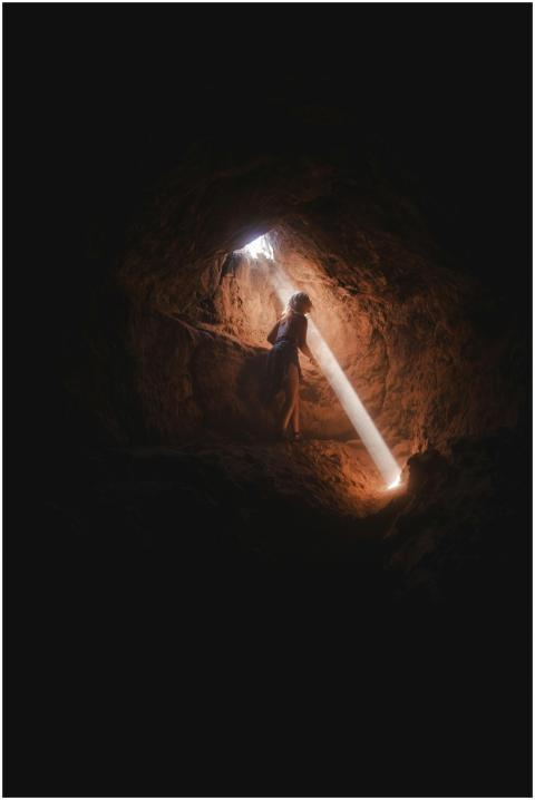 A lone adventurer explores a dark cave, illuminate
