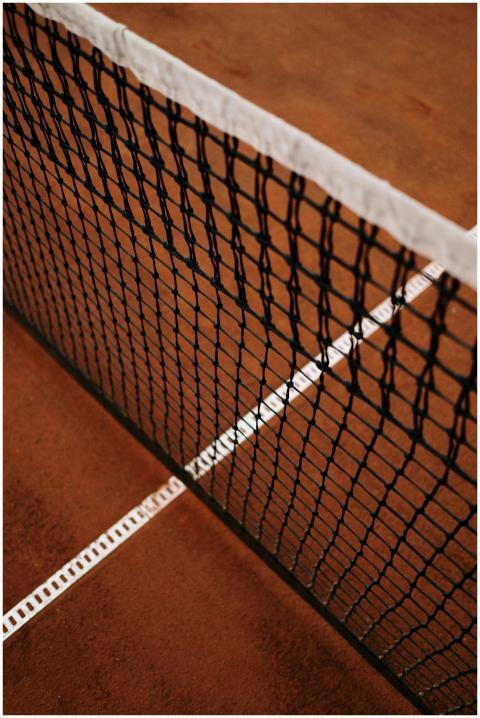Detailed close-up of a tennis net on a clay court