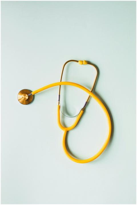 Top view of yellow medical stethoscope placed on w