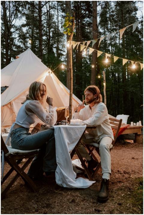 A couple enjoys a romantic dinner outside a tent i