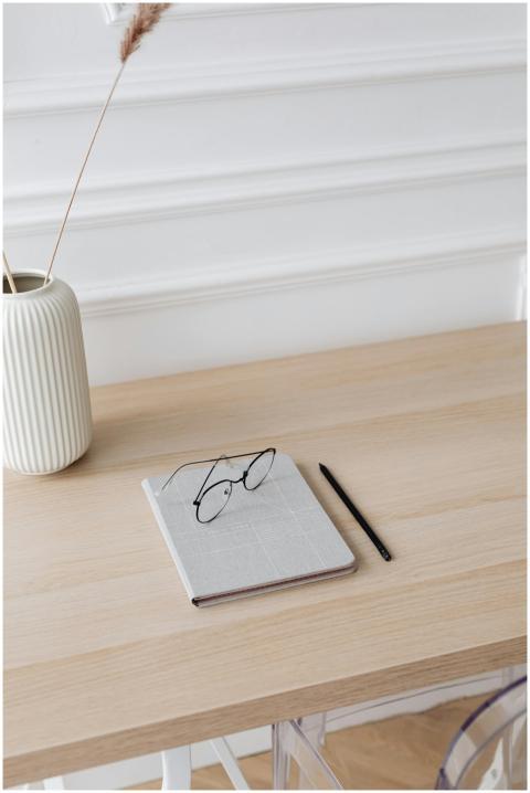 Minimalist desk with a notebook, eyeglasses, and a