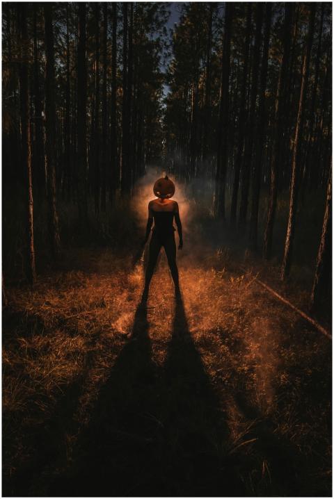 Eerie silhouette of person with pumpkin head in a