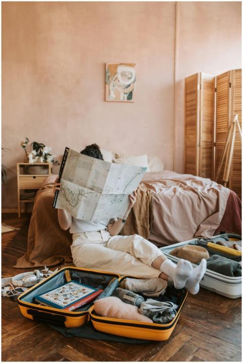 A woman sitting on the floor reading a map, surrou