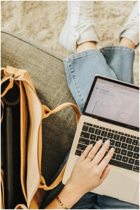 A person using a laptop with an elegant tote bag n