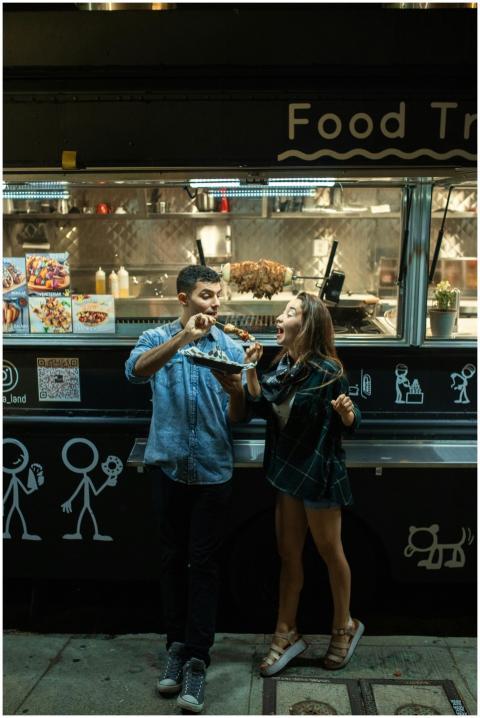 A joyful couple enjoying food at a trendy food tru