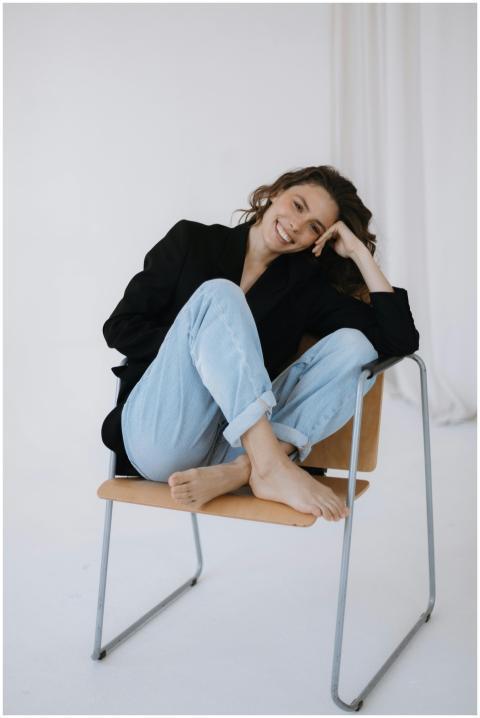 A cheerful woman in casual attire sitting on a cha