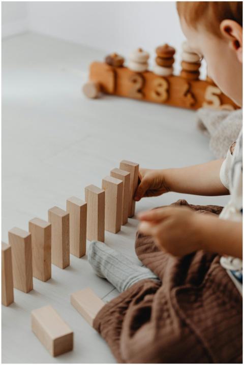 A young child is building with wooden blocks indoo
