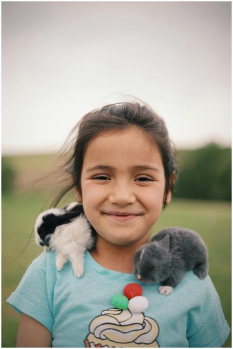Portrait of a smiling girl with two bunnies on her
