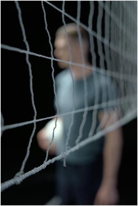 A blurred volleyball player stands behind a sharpl