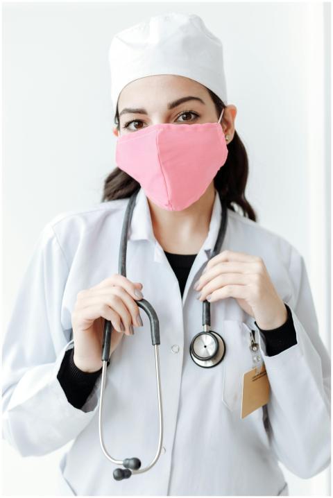 A doctor wearing a pink face mask and a stethoscop