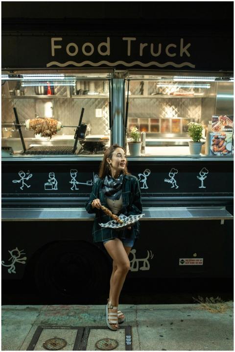 Woman enjoying street food at night near a stylish