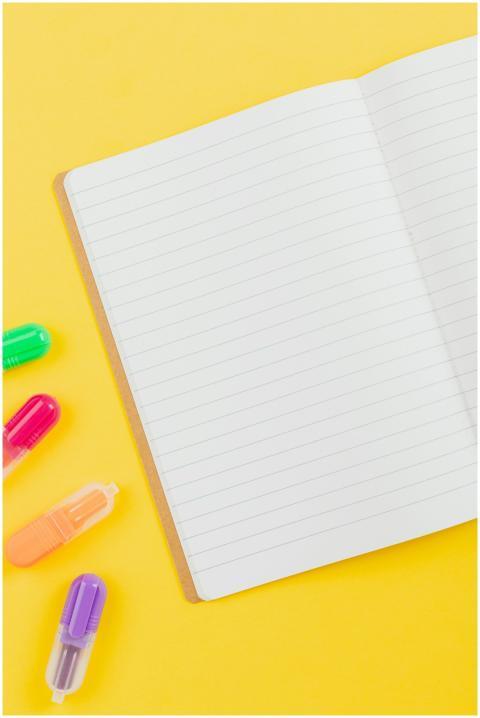 Flat lay of colorful highlighters and an open note