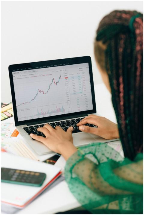 A woman working on financial analysis using a lapt