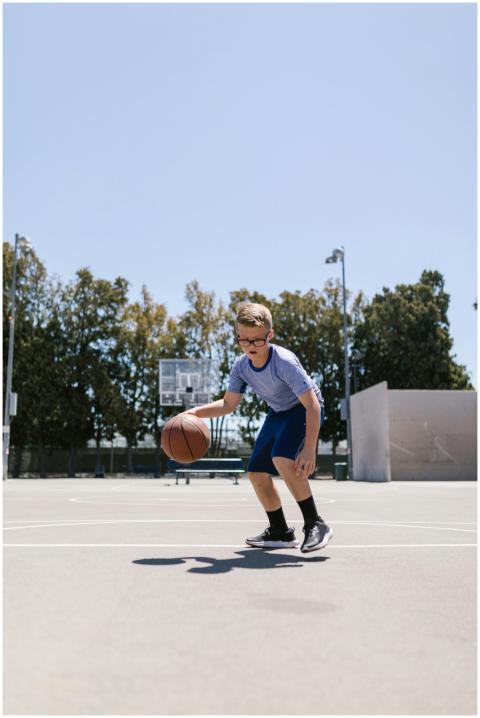 A young boy playing basketball on an outdoor court