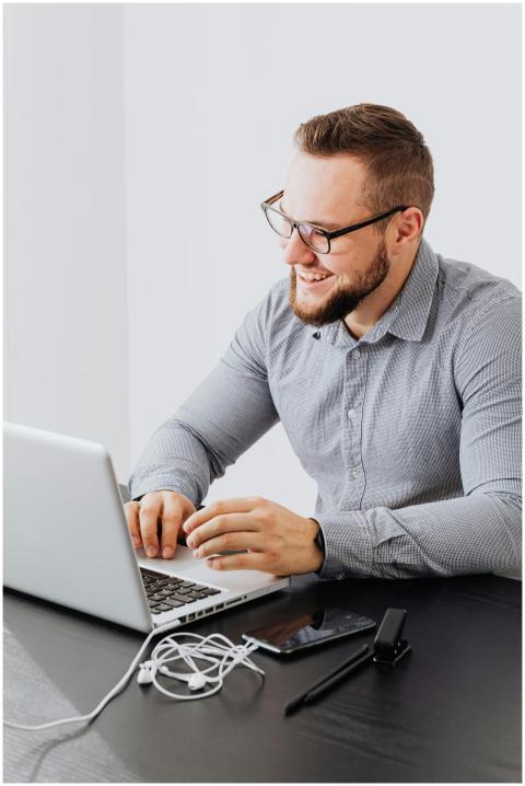 Portrait of a smiling bearded man using a laptop i