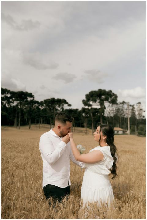 A couple shares a tender moment in a golden wheat