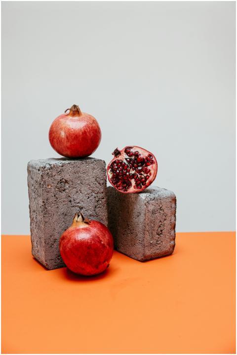 A minimalist still life image featuring pomegranat