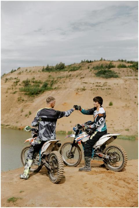 Two young motocross riders sharing a fist bump ato