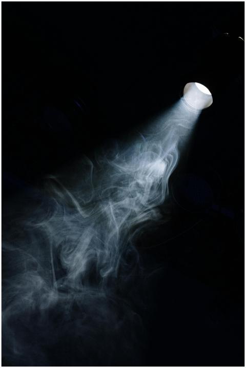 A beam of light penetrates through smoke in a dark