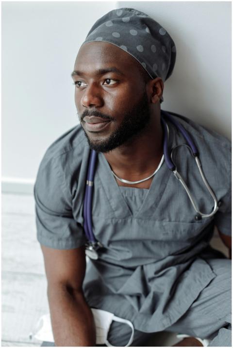 African American male nurse sitting contemplativel