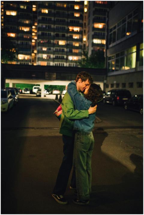 A couple shares a tender embrace in an urban setti