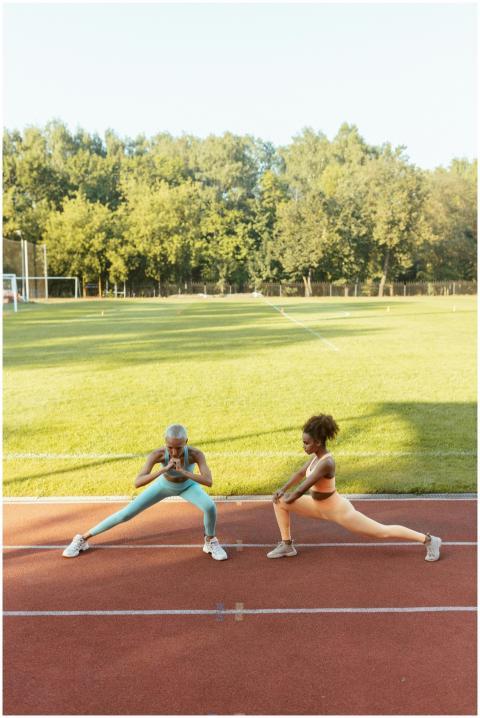 Two women performing stretching exercises on a sun