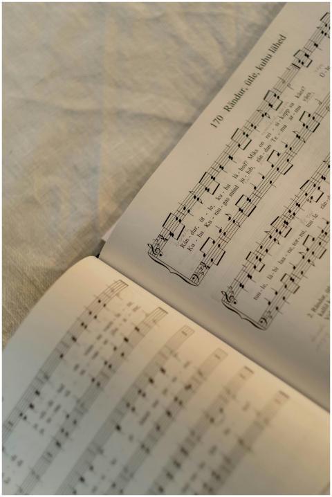 A close-up shot of an open hymnbook displaying mus