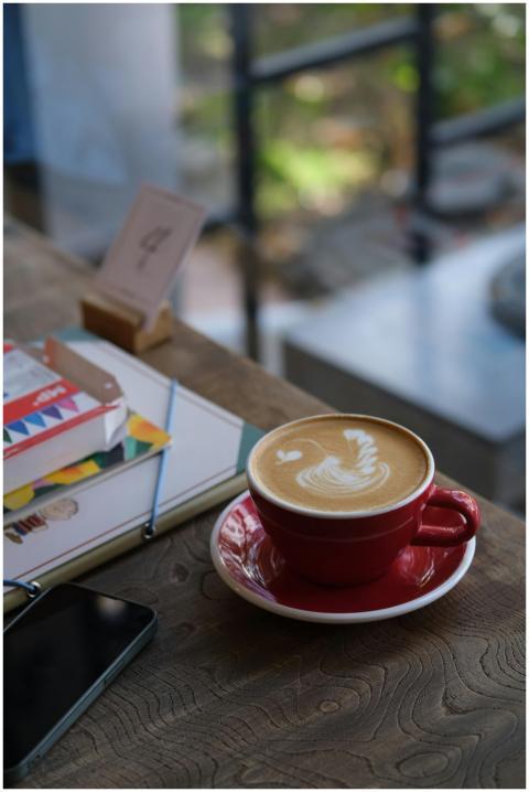 Close-up of a latte with latte art in a red cup on