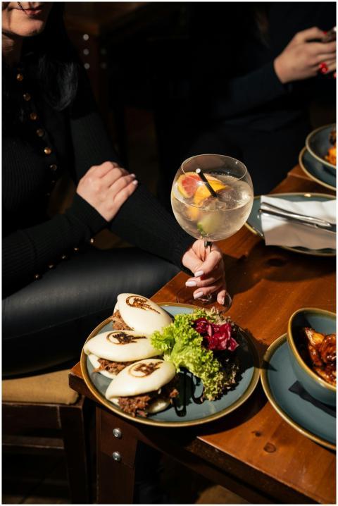 Elegant dining scene with bao buns and cocktails o