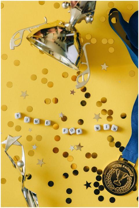 Gold trophy and medal with celebratory confetti an