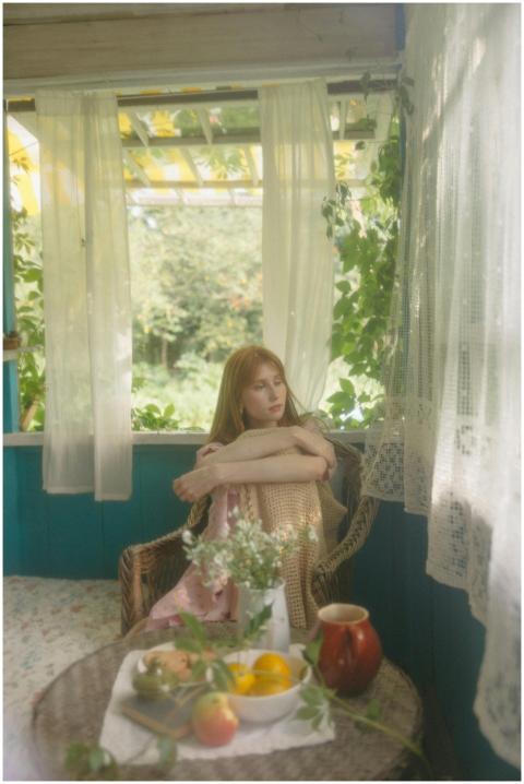 A contemplative woman by the window in a vintage r