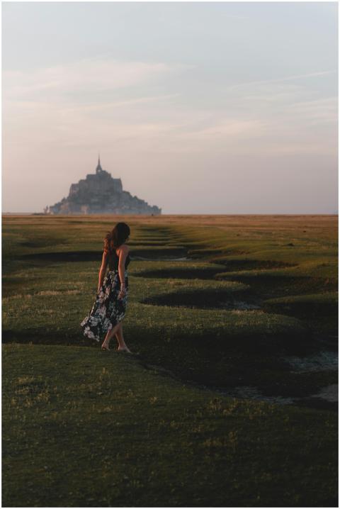 A woman in a floral dress walks towards Le Mont-Sa