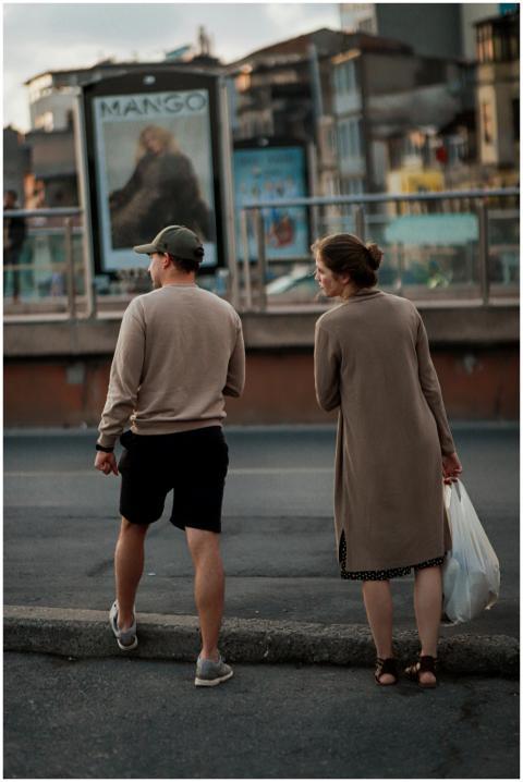 Rear view of a couple standing on a city curb, obs