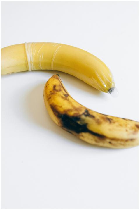 Two bananas, one wrapped in a condom, symbolizing
