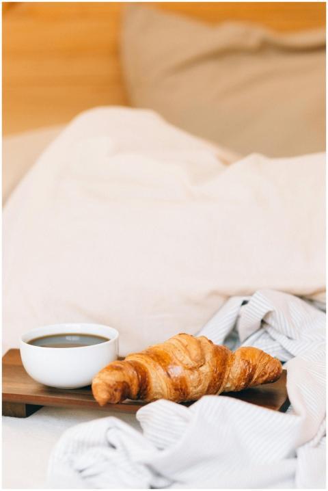 Warm croissant and coffee on a wooden tray, perfec