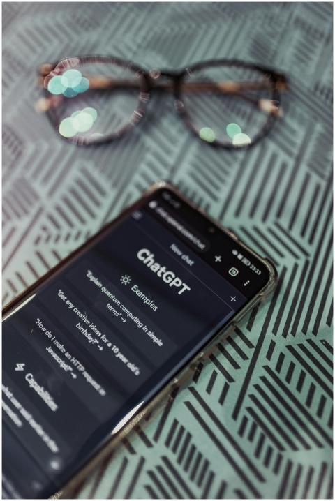 Smartphone with ChatGPT app interface next to eyeg