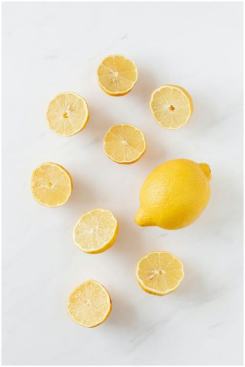 A flat lay of whole and sliced fresh lemons on a c
