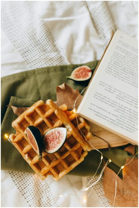 Warm waffles topped with fresh figs, set on a text