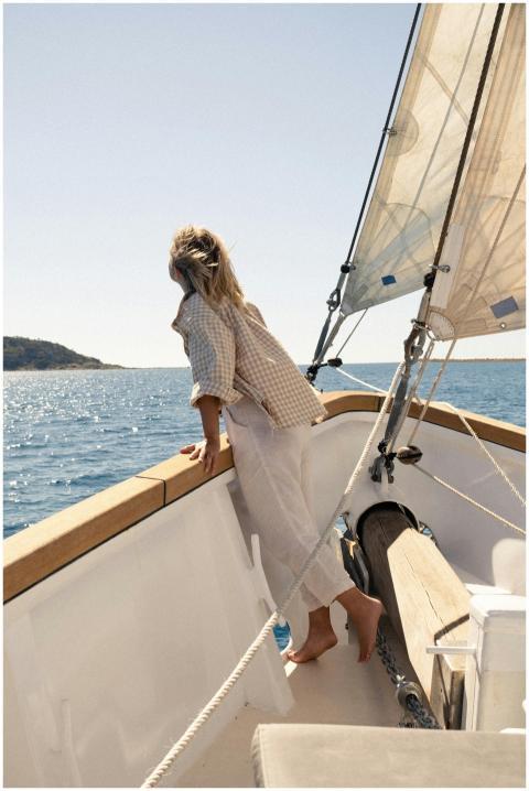 A woman enjoys a sunny day sailing on the ocean wi