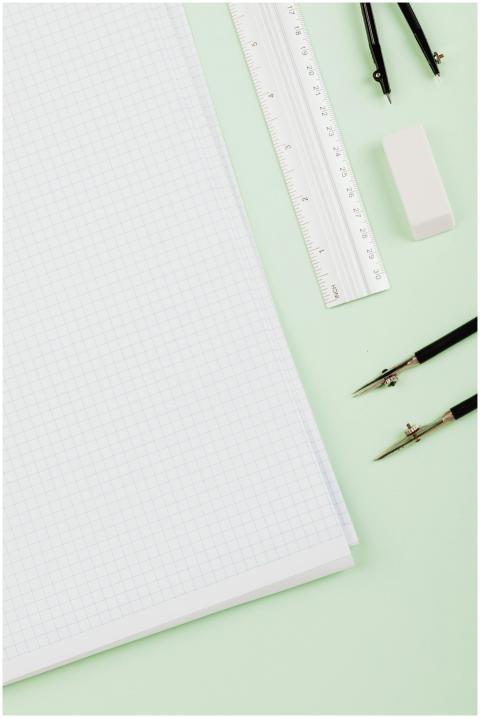 A vertical shot featuring drafting tools on graph