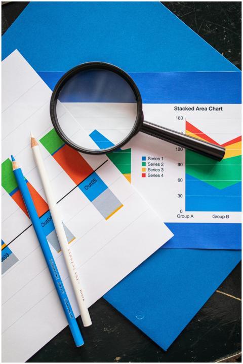Image of financial charts and magnifying glass, id