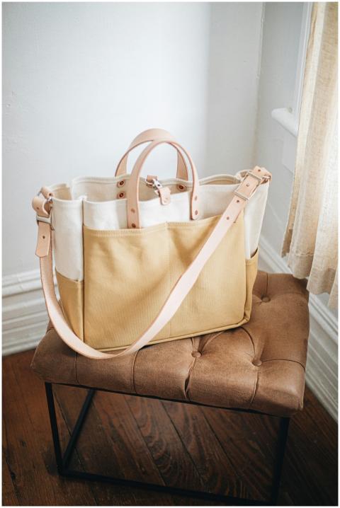 A handcrafted canvas and leather tote bag on a sty