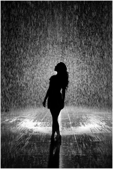 Artistic silhouette of a woman enjoying the rain.